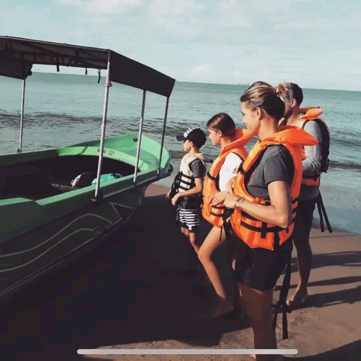 Guests boarding the boat from the shallow water