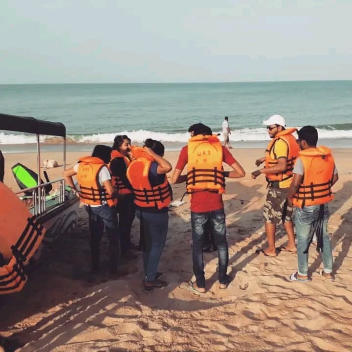 A group of guests in life jackets on the beach before a tour
