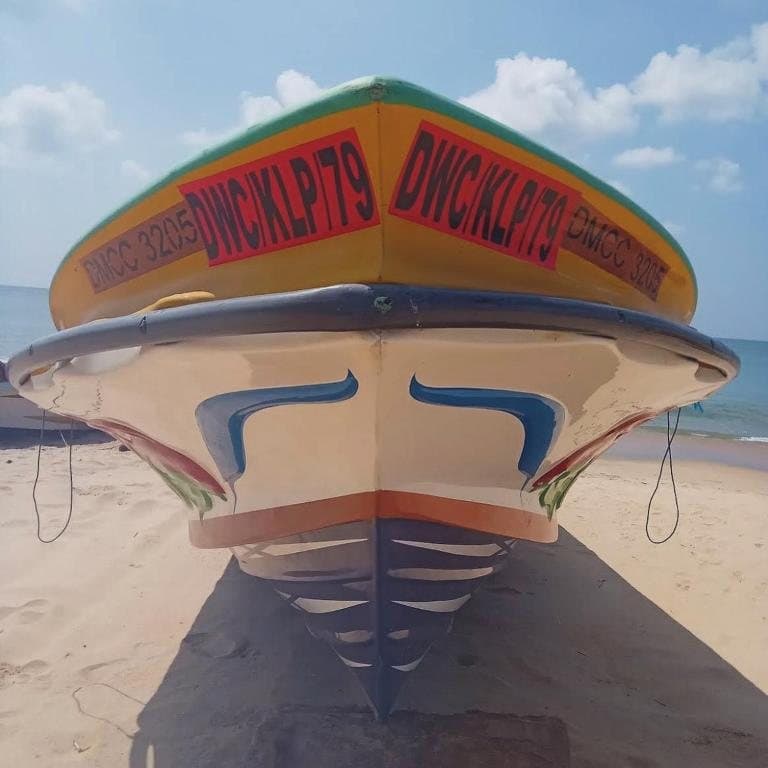 The bow of a traditional wooden fishing boat on the sand