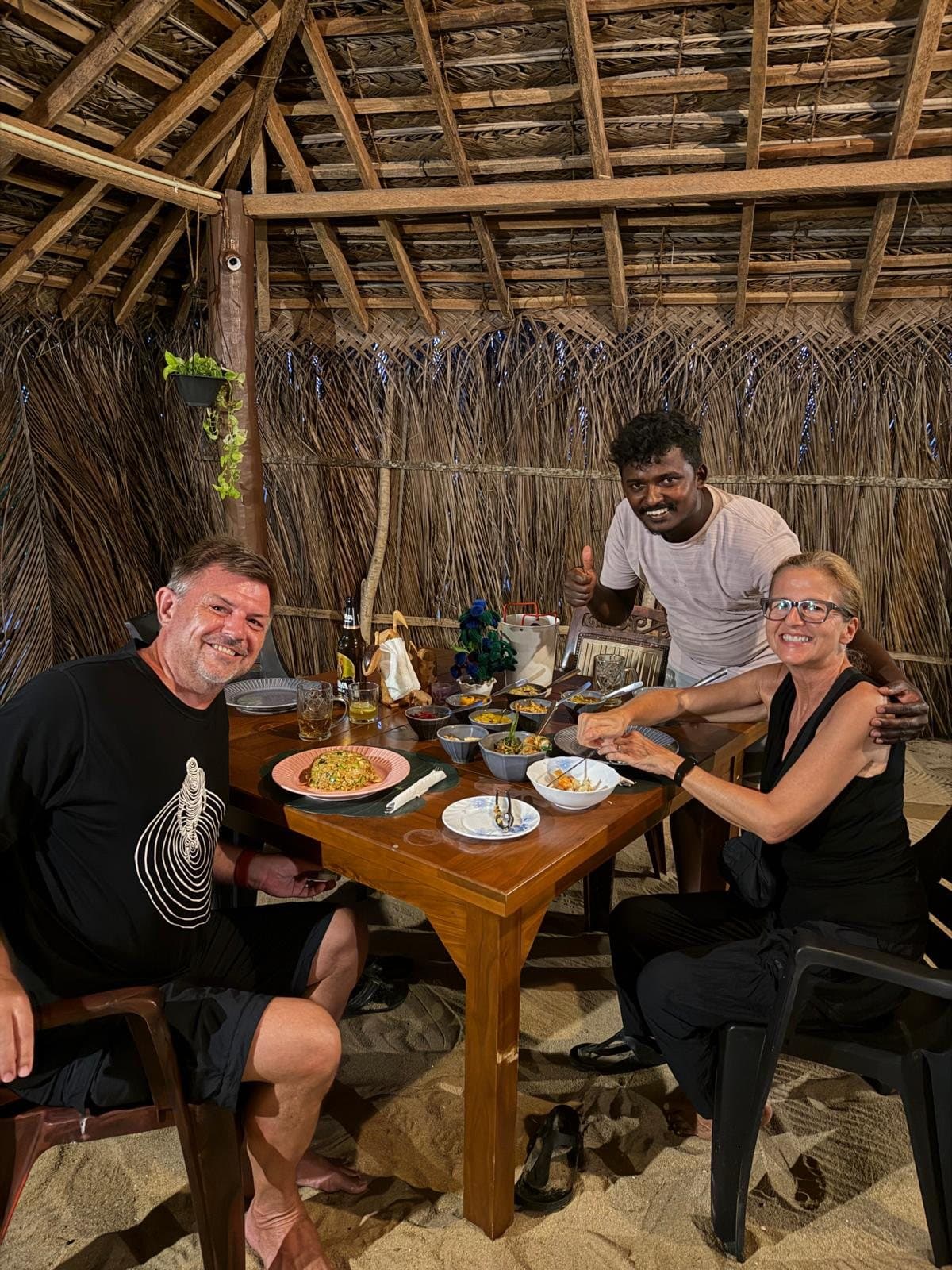 A couple dining with Maduka in the beach restaurant