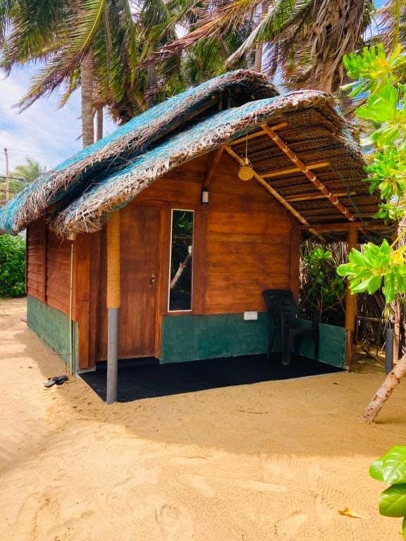 A thatched timber chalet surrounded by green foliage